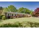 Quaint brick home featuring manicured lawn, colorful shrubs, and a classic, inviting facade at 3397 Old Jonesboro Rd, Hapeville, GA 30354