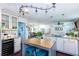 Open kitchen layout with white cabinets, an island with seating, and views into the living and dining areas at 3397 Old Jonesboro Rd, Hapeville, GA 30354