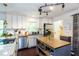 Bright kitchen with white cabinets, track lighting, and a center island with a butcher block top at 3397 Old Jonesboro Rd, Hapeville, GA 30354