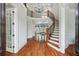Bright foyer with hardwood floors, curved staircase, chandelier, and views into the living room at 5422 Heyward Square Pl, Marietta, GA 30068