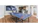 Finished basement game room with ping pong table, hardwood floors, and convenient wet bar at 5422 Heyward Square Pl, Marietta, GA 30068