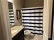 Bathroom featuring striped shower curtain, granite countertop, and dark cabinetry at 187 Slate Dr, Buford, GA 30518