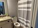 Cozy bathroom with striped shower curtain and granite countertop, offering a serene retreat at 187 Slate Dr, Buford, GA 30518