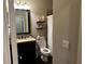 Bathroom with dark vanity, tiled shower, shelves, and neutral decor at 187 Slate Dr, Buford, GA 30518