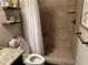 Close up of bathroom featuring a tiled shower, floating shelves, and neutral decor at 187 Slate Dr, Buford, GA 30518