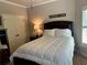 Bedroom with crisp white bedding and comfortable dark wood bedframe at 187 Slate Dr, Buford, GA 30518