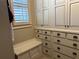 Well-organized closet with custom cabinets and a built-in bench, offering a comfortable space to store and organize clothes at 187 Slate Dr, Buford, GA 30518