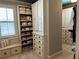 Custom walk-in closet with built-in shelving, drawers, and cabinet space for storage and organization at 187 Slate Dr, Buford, GA 30518