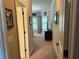 Hallway with tan carpet and tan walls leading to bedrooms with plentiful light at 187 Slate Dr, Buford, GA 30518