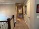 Hallway with neutral walls, white doors and trim, and plush carpet with a glimpse into another room at 187 Slate Dr, Buford, GA 30518