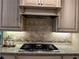 Gourmet kitchen features granite countertops, custom cabinetry, and a sleek cooktop for culinary enthusiasts at 187 Slate Dr, Buford, GA 30518