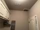 Well-organized laundry room with white cabinets and a stylish laundry schedule sign at 187 Slate Dr, Buford, GA 30518