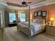 Elegant main bedroom with a four-poster bed, tray ceiling, and neutral decor at 187 Slate Dr, Buford, GA 30518