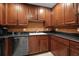 Kitchen featuring dark wood cabinets, black countertops, stainless steel appliances, and ample storage at 195 14Th St # 1403, Atlanta, GA 30309