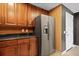 This kitchen features granite countertops, stainless-steel refrigerator, and stained wooden cabinetry at 195 14Th St # 1403, Atlanta, GA 30309