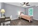 Comfortable bedroom with hardwood floors, a ceiling fan, and a well-lit desk area at 4095 Fastnet Ln, Duluth, GA 30096