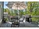 A view of a charming deck, furnished with a dining set, a grill, and shaded by an umbrella for outdoor relaxation at 4095 Fastnet Ln, Duluth, GA 30096