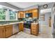 Well-lit kitchen with stainless steel appliances and wooden cabinets, open to adjacent living space at 4095 Fastnet Ln, Duluth, GA 30096