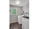 Functional laundry room featuring a window, shelves, and modern washer and dryer units at 4095 Fastnet Ln, Duluth, GA 30096