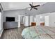 Main bedroom with grey wood floors, ensuite bathroom, and large TV at 4095 Fastnet Ln, Duluth, GA 30096