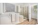 Bright bathroom showcasing a walk-in tub and a glass enclosed shower, with tile flooring at 4930 Kings Common Way, Cumming, GA 30040