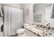 Well-lit bathroom with granite countertops, a single sink vanity, and a shower-tub combo at 4930 Kings Common Way, Cumming, GA 30040