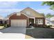 Charming brick home featuring a two-car garage, manicured lawn, and inviting entrance at 4930 Kings Common Way, Cumming, GA 30040