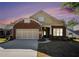 Charming single-Gathering brick home with a two-car garage and well-manicured lawn at dusk at 4930 Kings Common Way, Cumming, GA 30040