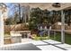 Outdoor deck area with shaded pergola, built-in grill, and seating beneath mature trees at 1205 Club Walk Ne Dr, Brookhaven, GA 30319