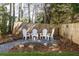 Backyard gravel seating area with white adirondack chairs and a wood privacy fence at 1205 Club Walk Ne Dr, Brookhaven, GA 30319