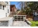 A backyard features a BBQ island with a grill, sink, mini-fridge, counter seating and a stone patio with lawn at 1205 Club Walk Ne Dr, Brookhaven, GA 30319