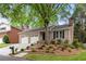 Charming brick home featuring a two-car garage, mature trees, and a well-manicured front yard at 1205 Club Walk Ne Dr, Brookhaven, GA 30319