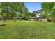 Large backyard features a well-maintained lawn, mature trees, and a chicken coop at 1217 Topaz Ln, Villa Rica, GA 30180