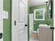 Bathroom with green walls, white subway tile in the tub, modern mirror, and single sink vanity at 1217 Topaz Ln, Villa Rica, GA 30180