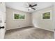 Bedroom with neutral carpet and trim, featuring multiple windows and ceiling fan at 1217 Topaz Ln, Villa Rica, GA 30180