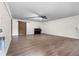 Spacious living room featuring hardwood floors, a ceiling fan, and stylish brick accent wall with barn door at 1217 Topaz Ln, Villa Rica, GA 30180