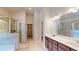 Modern bathroom featuring a glass-enclosed shower, dual vanity sinks, and tile floor at 1673 Dover Creek Ln, Lawrenceville, GA 30045