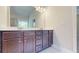 Bathroom vanity with double sinks, wood cabinets, large mirror, and modern lighting at 1673 Dover Creek Ln, Lawrenceville, GA 30045