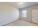 Carpeted bedroom with window, overhead lighting, and white door at 1673 Dover Creek Ln, Lawrenceville, GA 30045