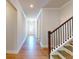 Inviting hallway featuring hardwood floors and a staircase with dark wood railings at 1673 Dover Creek Ln, Lawrenceville, GA 30045