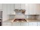 Modern kitchen with stainless steel vent hood, granite countertops, and white cabinets at 1673 Dover Creek Ln, Lawrenceville, GA 30045
