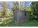 A storage shed nestled amongst the trees and foliage provides additional storage in the backyard at 1952 Don Juan Ln, Decatur, GA 30032