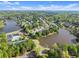 Wide aerial view of a neighborhood featuring a pond, a lake, and lots of greenery at 440 Hunt River Way, Suwanee, GA 30024