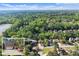 Scenic view of a neighborhood with densely packed trees, homes and a lake at 440 Hunt River Way, Suwanee, GA 30024