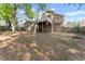 View of the home's rear featuring an elevated deck and yard covered with natural foliage at 440 Hunt River Way, Suwanee, GA 30024