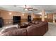 Open basement area features a large leather sofa, ceiling fan, wood-trim walls and a drop ceiling at 440 Hunt River Way, Suwanee, GA 30024