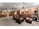 Basement living space with a large brown leather sofa, drop ceiling, and fitness equipment at 440 Hunt River Way, Suwanee, GA 30024