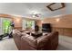 Finished basement with a comfortable leather sectional sofa, TV, ceiling fan, and outdoor access at 440 Hunt River Way, Suwanee, GA 30024