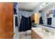 Cozy bathroom with tiled floors, a single sink vanity, and a blue shower curtain at 440 Hunt River Way, Suwanee, GA 30024