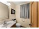 Cozy powder room with a wood door, toilet, sink, and mirror at 440 Hunt River Way, Suwanee, GA 30024